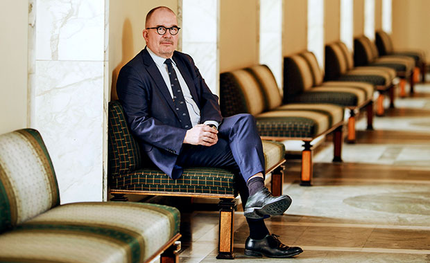 Antti Pelttari istumassa Eduskuntatalon käytävällä olevalla penkillä.