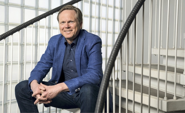 Professori Tuomas Ojanen istumassa rappusilla Helsingin yliopiston rappukäytävässä.